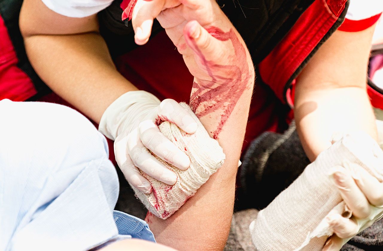 secouriste posant un bandage sur une blessure au bras