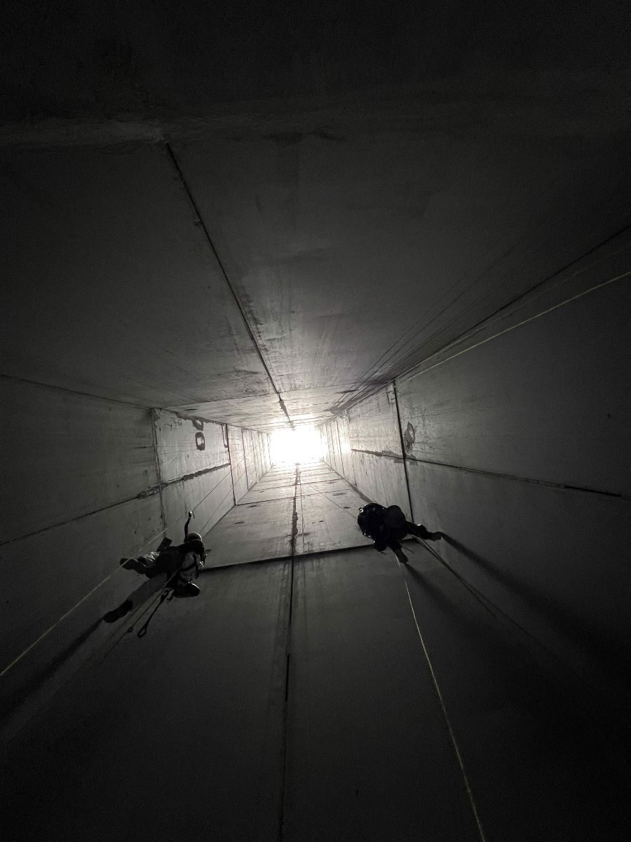 Cordistes Jarnias en progression verticale dans un puits bétonné, formés aux techniques de sécurité et d’accès difficiles"